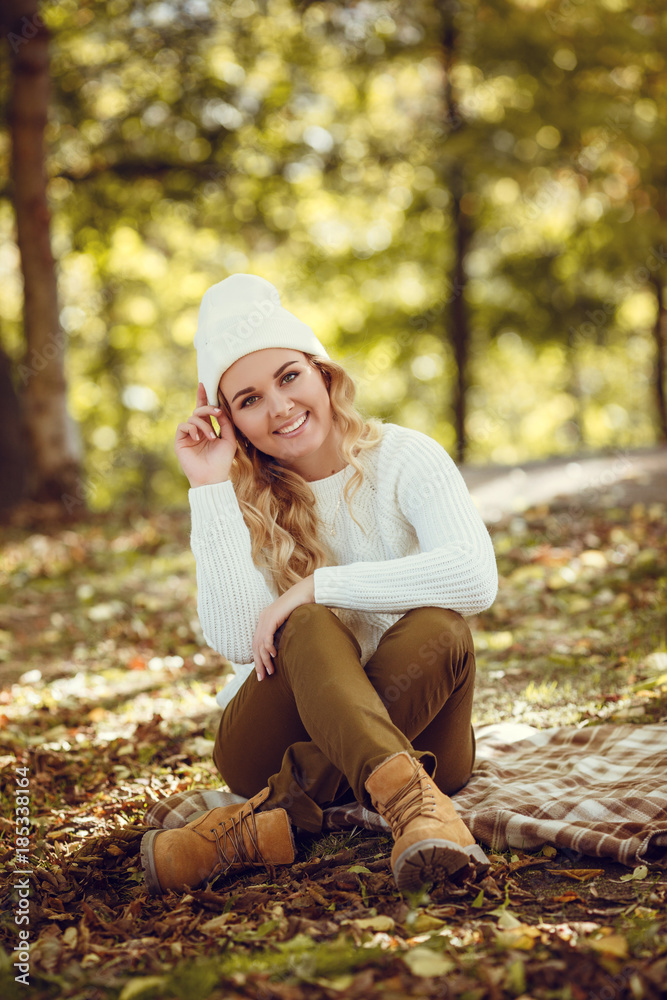 Beautiful elegant woman standing in a park in autumn Beautiful elegant woman standing in a park in autumn