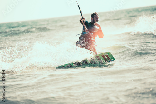 Kitesurfing Kiteboarding action photos man among waves quickly goes