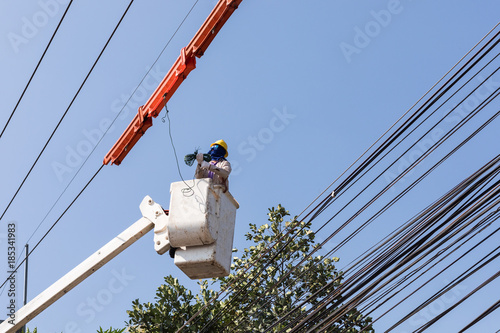 Photography Electrician working on high to put the device cover insulation on wires