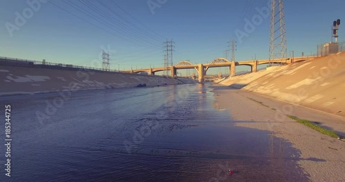 Pan over water surface LA river view 6th Street Bridge downtown city Los Angeles photo