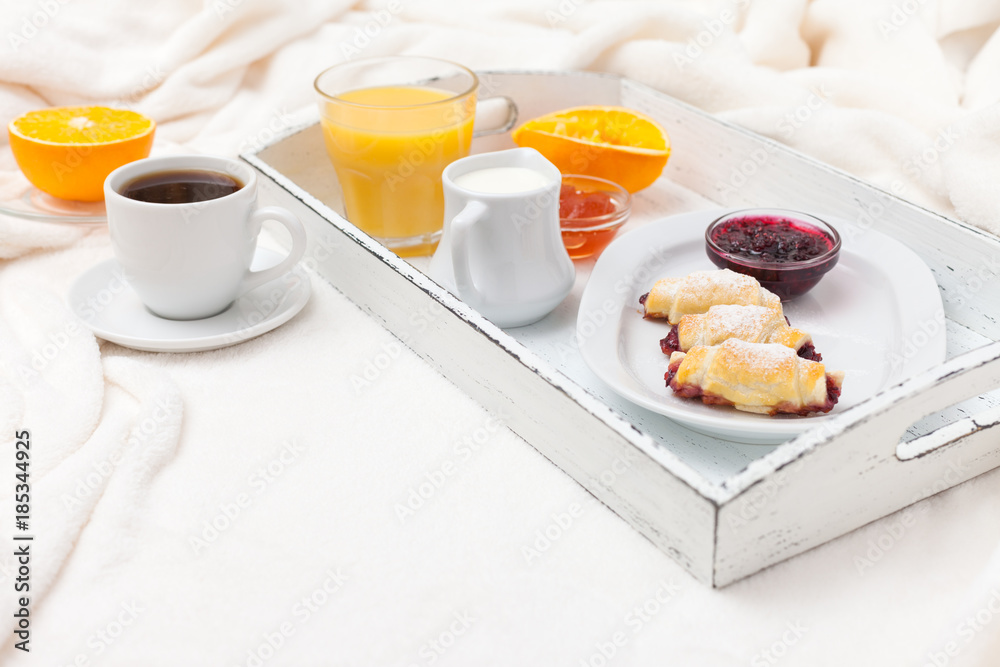 Freshly baked croissant, orange juice, jam, cup of black coffee on white wooden tray on plaid. Homemade cookie. Fresh pastries for breakfast. Delicious dessert. Closeup photography. Horizontal banner Freshly baked croissant, orange juice, jam, cup of black coffee on white wooden tray on plaid. Homemade cookie. Fresh pastries for breakfast. Delicious dessert. Closeup photography. Horizontal banner