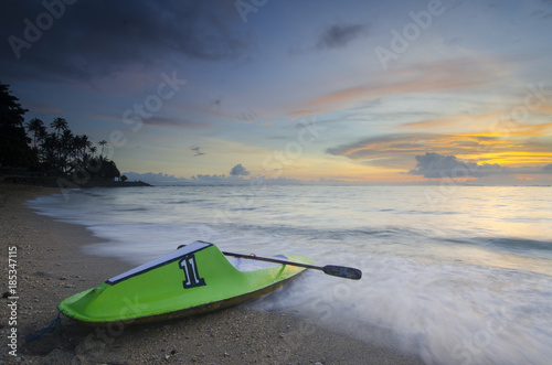 Green canoe at senggigi beach sunset, lombok island, indonesia photo