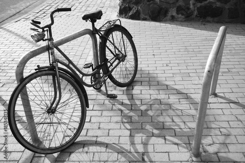 S/W Foto altes Fahrrad an einem Fahrradständer mit Schattenwurf der Sonne.Where: Blankenese Strandweg.When: 11.05.2011.
