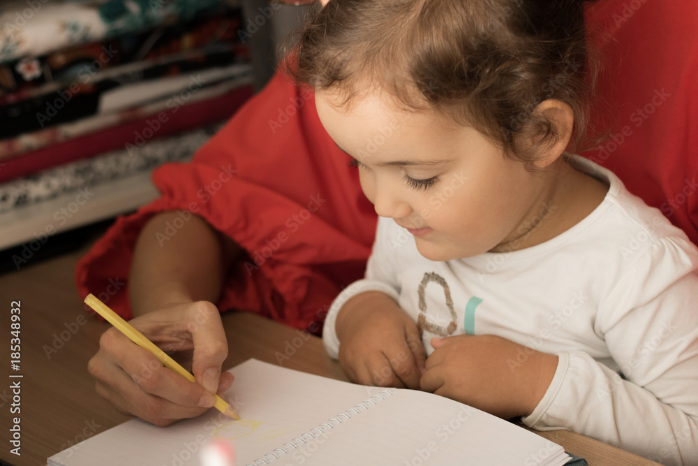 Mother is teaching daughter to write. Mother is teaching daughter to write.