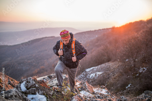 Fototapeta Naklejka Na Ścianę i Meble -  Hiker climbing on the mountain on cold winter day