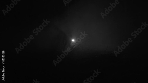 Silhouette of a man running through the forest at winter night