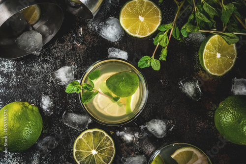 Homemade lemonade or mojito cocktail with fresh lime and mint leaves, dark rusty metal background, copy space top view