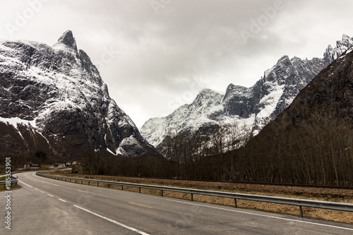 The road in Andalsnes with the majestic mountain peaks of tthe mountain massif Trolltindene in the background.