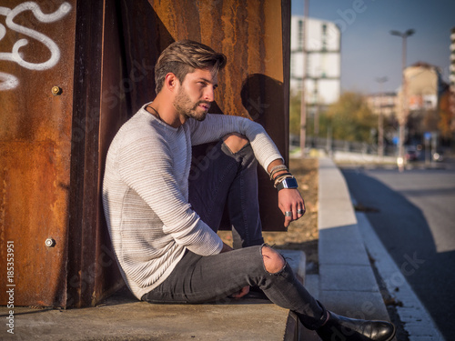 Fotografija One handsome man in urban setting in European city, sitting