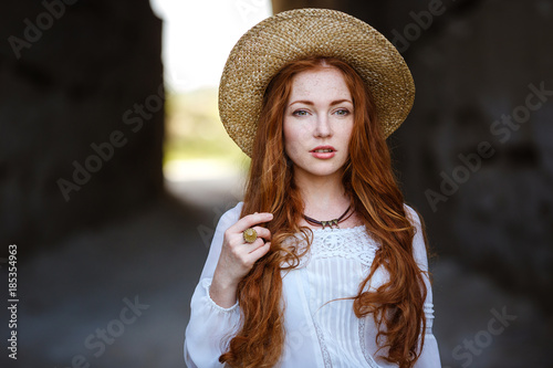 Summer portrait, beautiful freckled young woman wearing straw hat