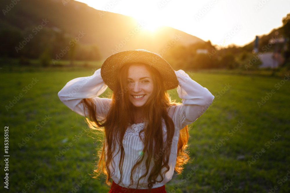 Fototapeta premium Summer portrait, beautiful freckled young woman wearing straw hat