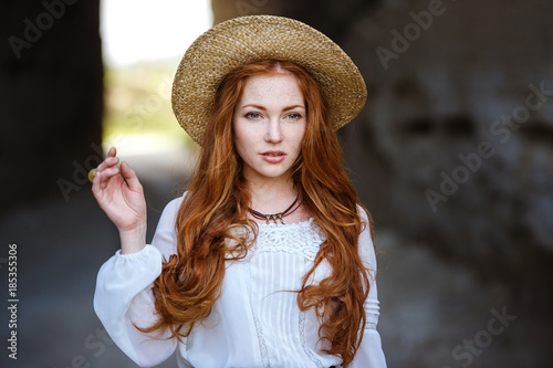 Summer portrait, beautiful freckled young woman wearing straw hat