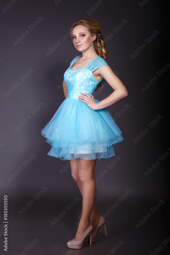 Naklejka premium Fashion studio shot of beautiful woman with makeup and hairstyle wearing evening dress