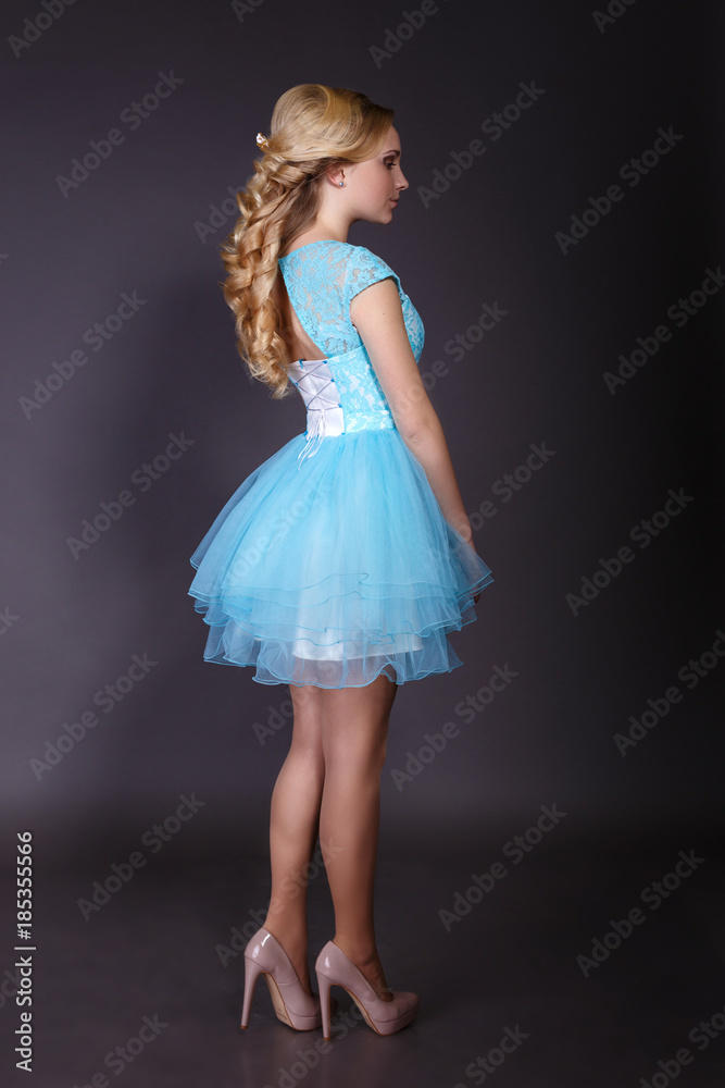 Fashion studio shot of beautiful woman with makeup and hairstyle wearing evening dress Fashion studio shot of beautiful woman with makeup and hairstyle wearing evening dress