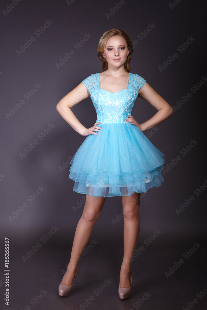 Fashion studio shot of beautiful woman with makeup and hairstyle wearing evening dress Fashion studio shot of beautiful woman with makeup and hairstyle wearing evening dress