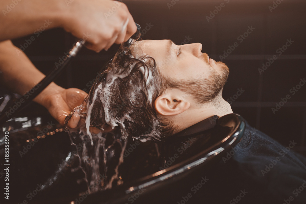 Barbershop. Hairstylist washing client hair in barber shop – Stock-Foto |  Adobe Stock