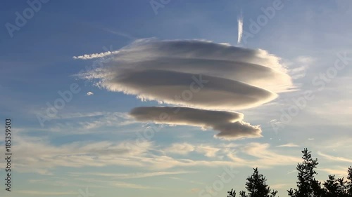 Large circular cloud forms (Altocumulus lenticularis duplicatus V-39) in the evening sky over Malaga city, Spain photo