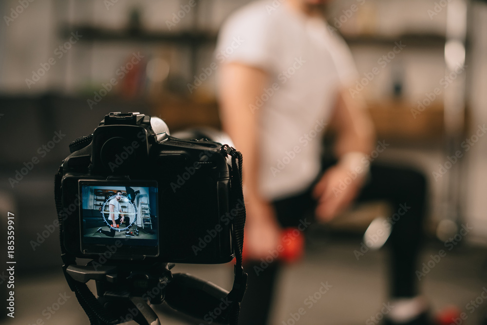cropped image of sport blogger showing how to train with dumbbells cropped image of sport blogger showing how to train with dumbbells