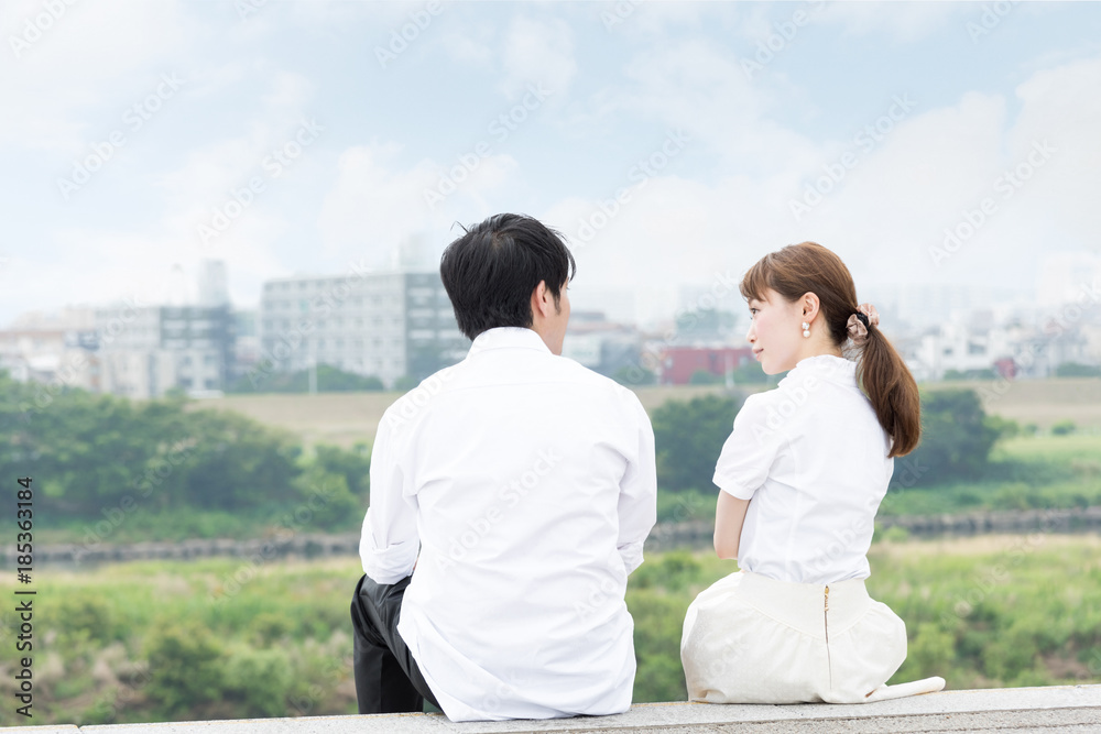 景色が綺麗な屋外で座って会話するカップル