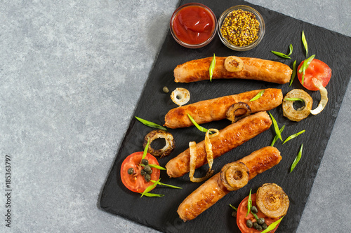 Fried sausages and vegetables on slate plate