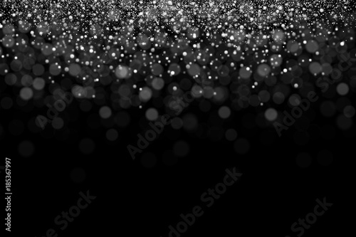 Silver glitter, snowing of grainy particles. Explosion of star dust with bokeh effect. Overlay texture, isolated on black background