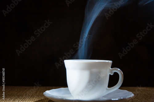 white coffee cup on dark wooden background. with copy space.
