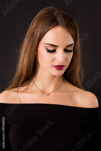 beautiful girl in a dress with open shoulders on a black background