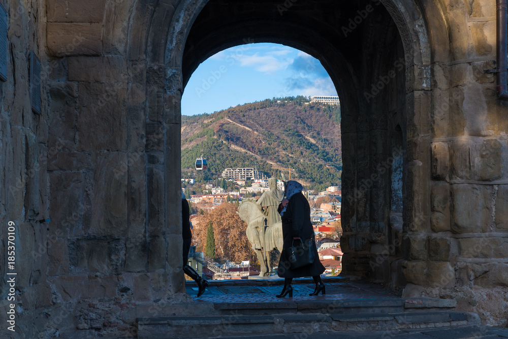 TBILISI, GEORGIA - DEC. 9, 2017 : An old lady is walking into the Metekhi Cathedral for morning service