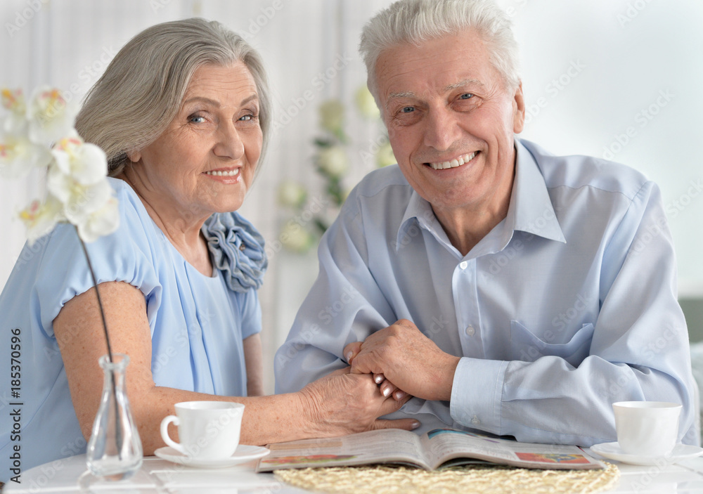 Senior couple drinking tea and reading magazine Senior couple drinking tea and reading magazine