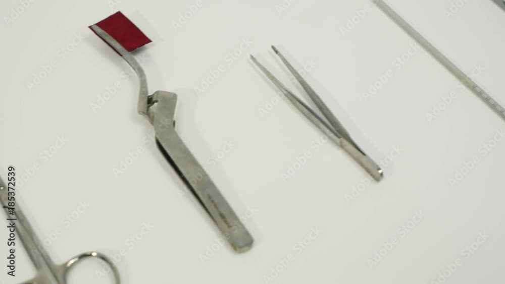 Dental instruments in dental cabinet. Close Up of medical instruments. On the table lies excavators dental, articulating tweezers curved, scissors, mouth mirror, syringe, college tweezers. Dental instruments in dental cabinet. Close Up of medical instruments. On the table lies excavators dental, articulating tweezers curved, scissors, mouth mirror, syringe, college tweezers.