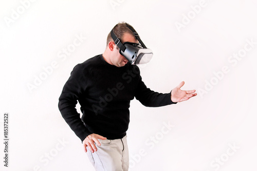 Handsome man wearing and playing virtual reality glasses on white background. Boy action in virtual reality helmet. Virtual reality headset. Young business man at office and using virtual reality box.