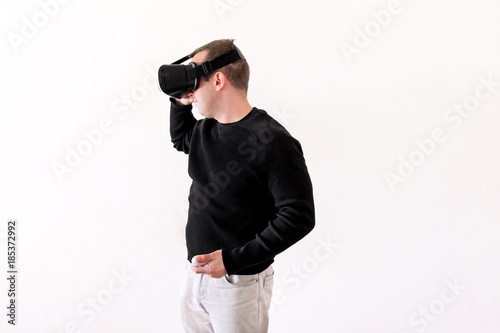 Handsome man wearing and playing virtual reality glasses on white background. Boy action in virtual reality helmet. Virtual reality headset. Young business man at office and using virtual reality box.