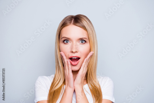 Omg! I am shocked! Close up portrait of joyful glad astonished beautiful attractive charming woman with open mouth, isolated on grey background