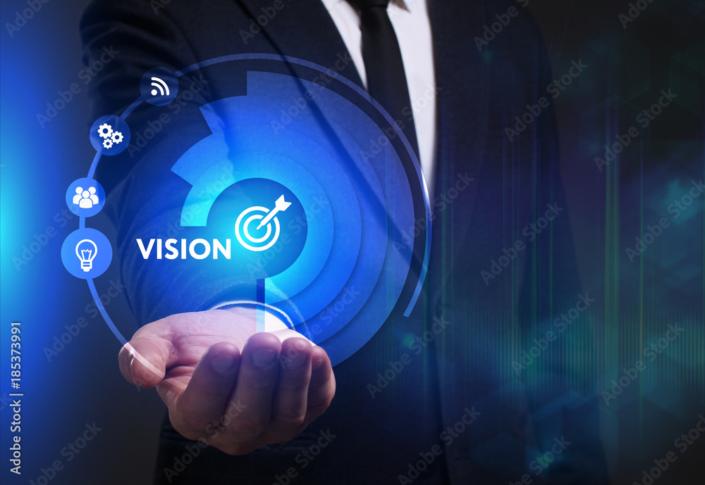 Business, Technology, Internet and network concept. Young businessman working on a virtual screen of the future and sees the inscription: Vision Business, Technology, Internet and network concept. Young businessman working on a virtual screen of the future and sees the inscription: Vision