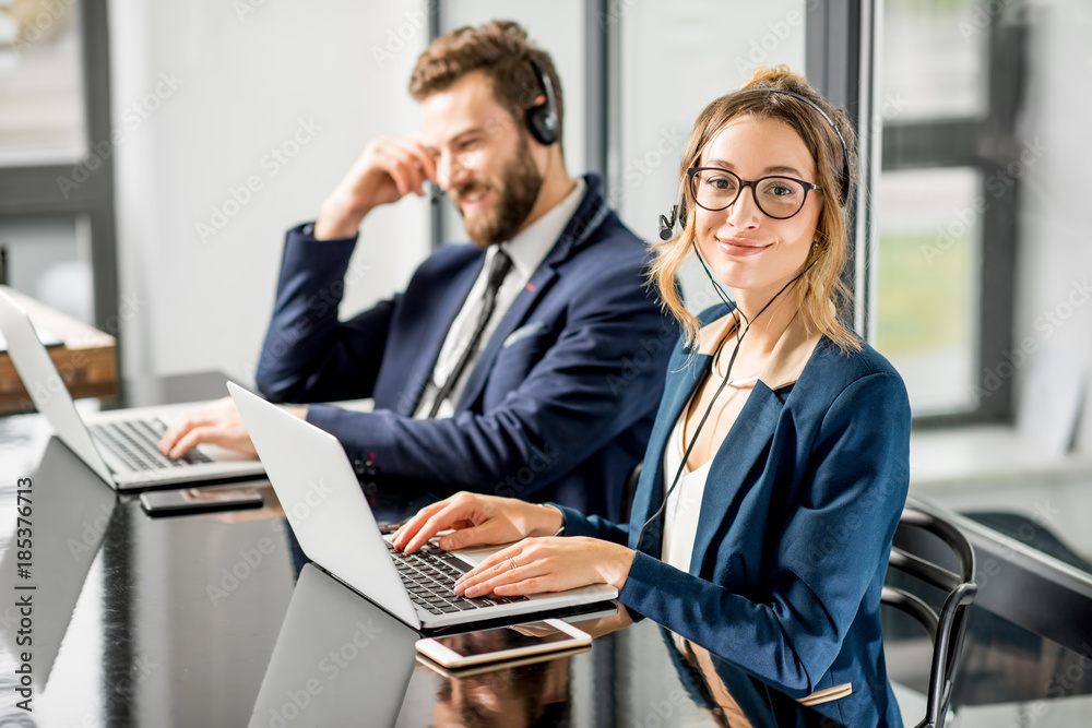 Business coworkers dressed in suits having oline conference with headset and laptop sitting at the office