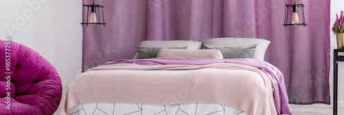 King-size bed against violet curtains
