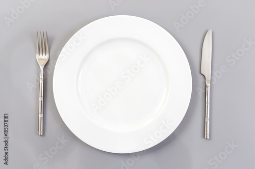 Empty Round Plate with Fork and Knife Top View Isolated on slate Background. Table Setting