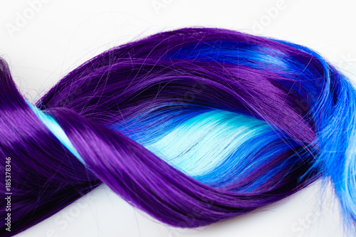 Curly voluminous shiny purple color hair on a white background