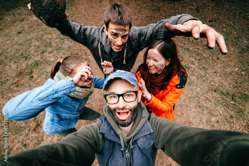 Four crazy funny people selfie. Bizarre scary company mess outdoor. Disgusting creepy fellows fooling around. Unusual dirty face emotions. Wide angle distortions. Evil family. Expressive pesrons party photo