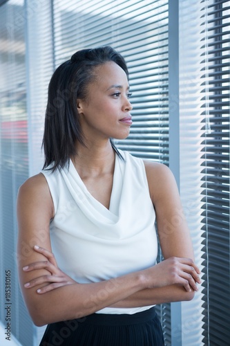 Female executives looking through window in office