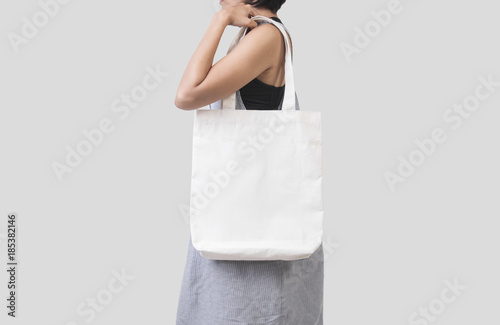 Girl is holding bag canvas fabric for mockup blank template isolated on gray background. photo