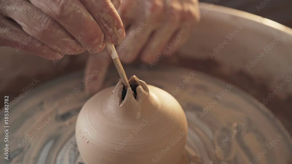 Potter uses a tool for cutting clay and shaping. Ceramist makes a clay