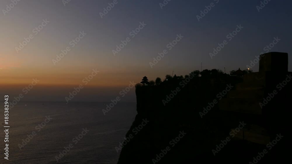 Ocean swells at Uluwatu, landmark cliff-top temple at sunset Ocean swells at Uluwatu, landmark cliff-top temple at sunset