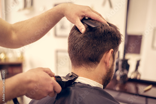 Barber making male haircut. Hairdresser cutting hair of client