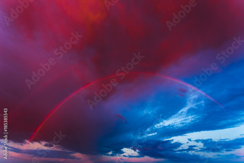 Double rainbow in the purple evening sky © lukjonis