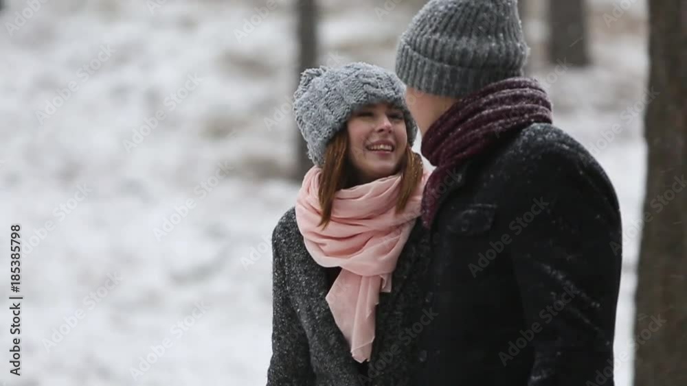 Outdoor winter forest shot of young wedding couple walking and having fun holding hands in snow weather pine forest during snowfall. Snowy engagement ceremony. Outdoor winter forest shot of young wedding couple walking and having fun holding hands in snow weather pine forest during snowfall. Snowy engagement ceremony.