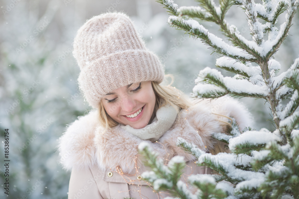 Portrait of cute girl looks to a spruces in a winter day