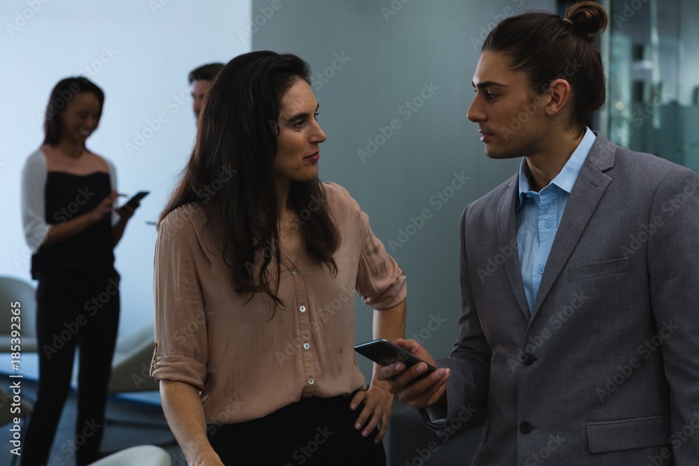 Businessman discussing with his coworker over mobile phone Businessman discussing with his coworker over mobile phone