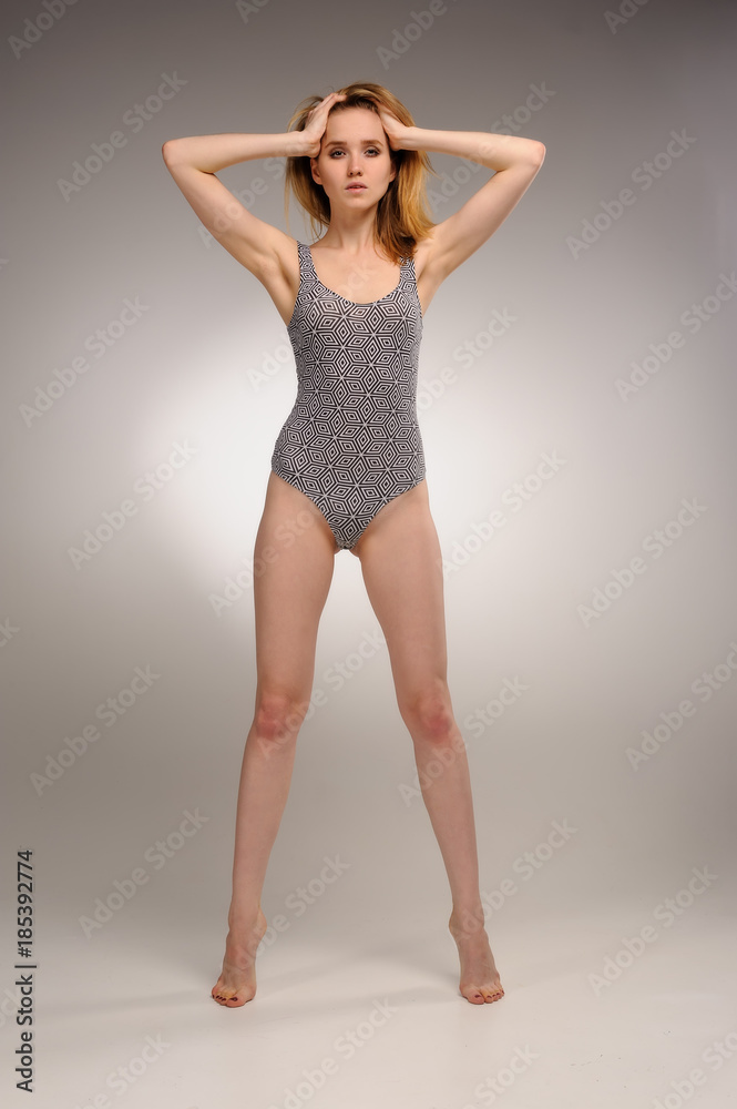 Attractive young woman in gymnastic suit holds head