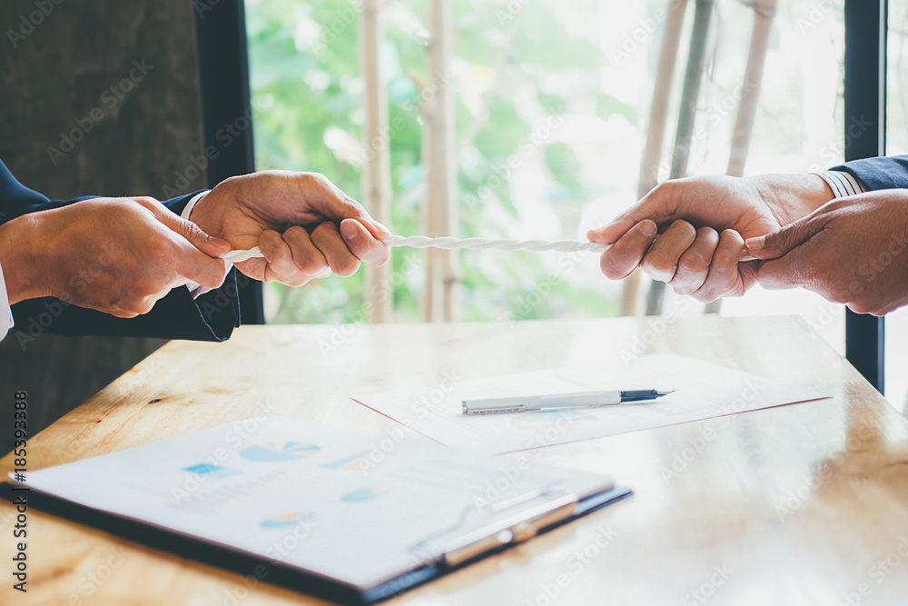 Business Cooperation Concept. close-up of a two businesspeople Hand Playing Tug Of War In Office.